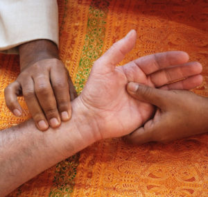 Taking the pulses, the primary diagnostic technique of Ayurveda.