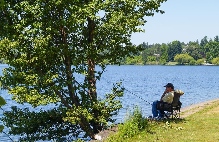 Lone fisherman sitting at a lake